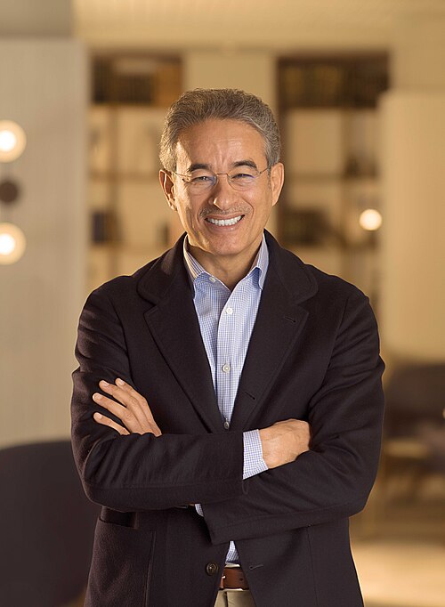 Professional portrait of Mohamed Alabbar wearing a dark jacket and shirt.